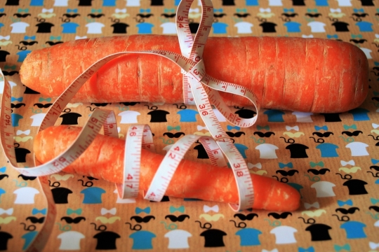 桌面上软尺绑新鲜橙色胡萝卜