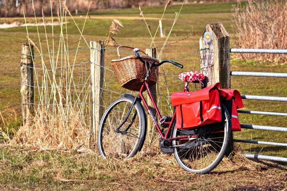 郊外栅栏旁停放着红色自行车