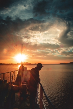 摄影师乘船水面拍摄金色夕阳美景