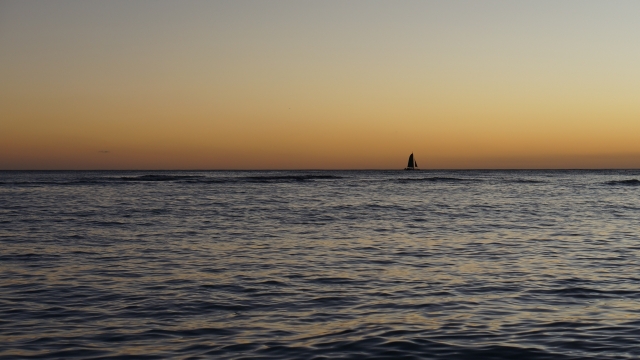 遥远海平面飘荡帆船夕阳风光