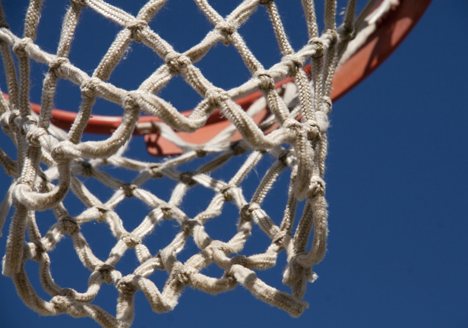 蓝色背景阳光下的篮球框近距离摄影
