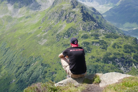 阳光户外山峰顶端成年男性背影