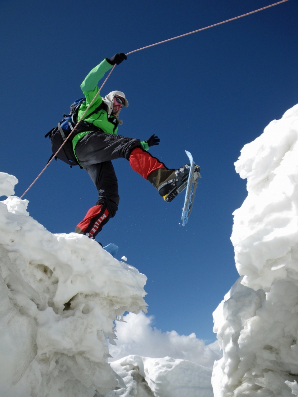 滑雪男子男子拉着绳子跨越雪山沟壑
