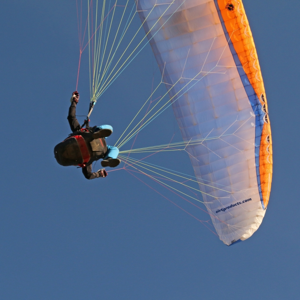 蓝色天空下滑翔伞运动员