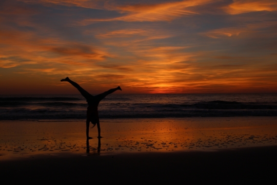 日落时分的大海海滩上倒立的人
