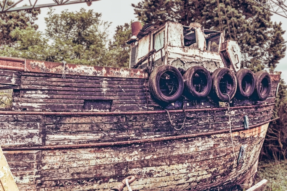 户外自然树木间古老破旧轮船