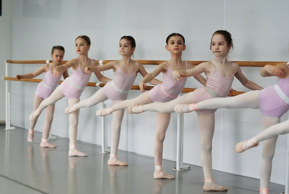 芭蕾教室扶木制栏杆练习舞蹈女孩们