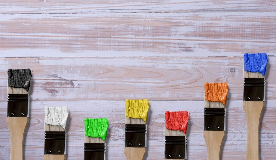 木制桌面蘸彩色颜料绘画刷子