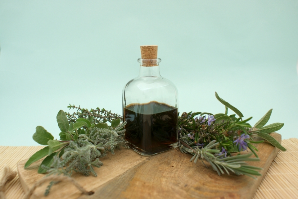 绿色背景木制桌面自然植物玻璃瓶食用油