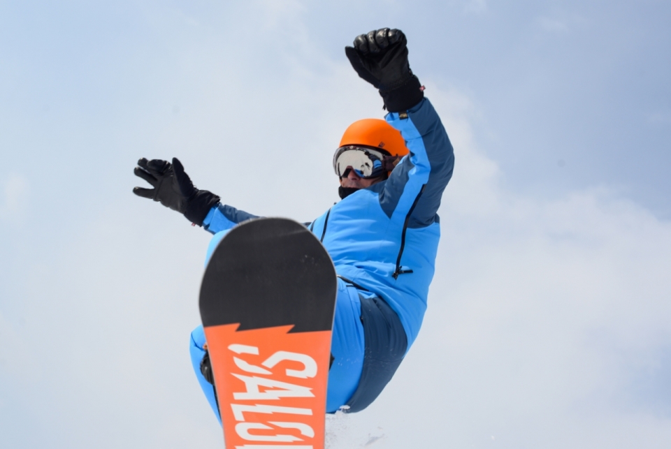 人物摄影_户外蓝色天空下橙色滑板运动服男性