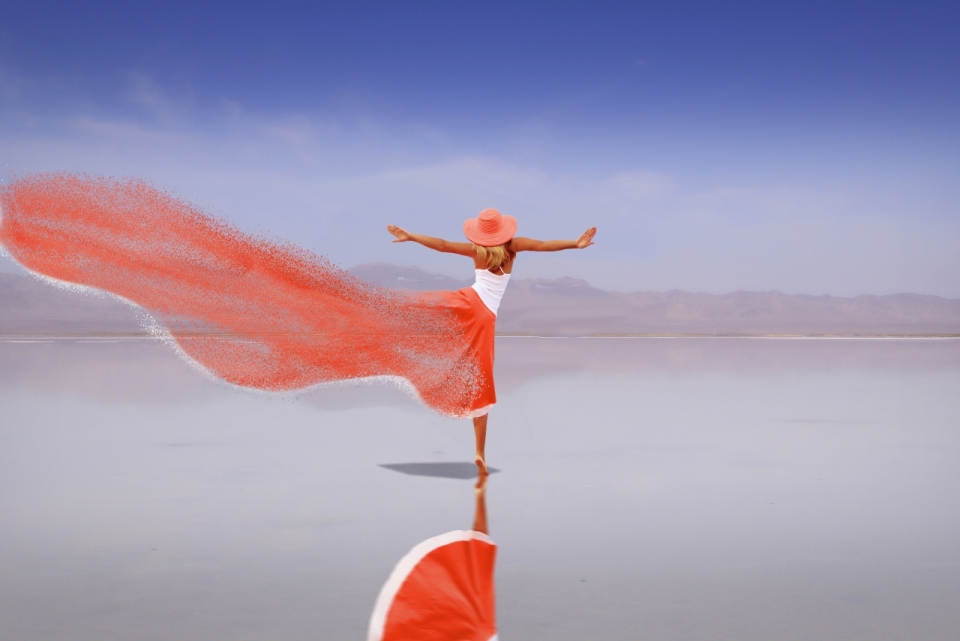 平静湖面上起舞的红裙女性背影