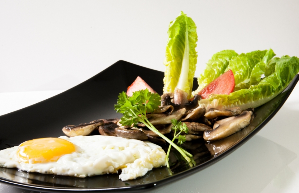 黑色餐盘中荷包蛋蘑菇蔬菜美食摄影