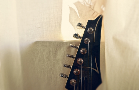 米白色纯棉布上的吉他弦特写