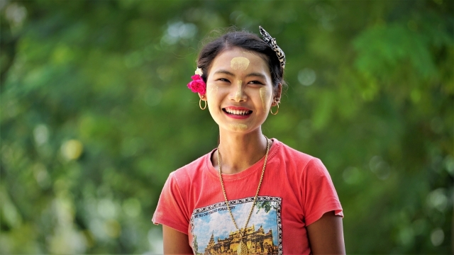 虚化背景户外戴花朵装饰微笑女性