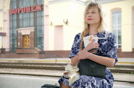 马路大街上坐着一个抱着书本和手提包的妇女