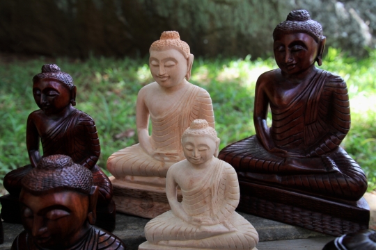 寺庙草坪前木制宗教雕刻佛像