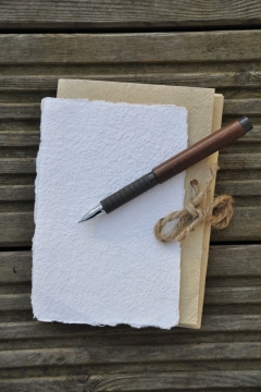 木头桌子上复古白色本子和笔