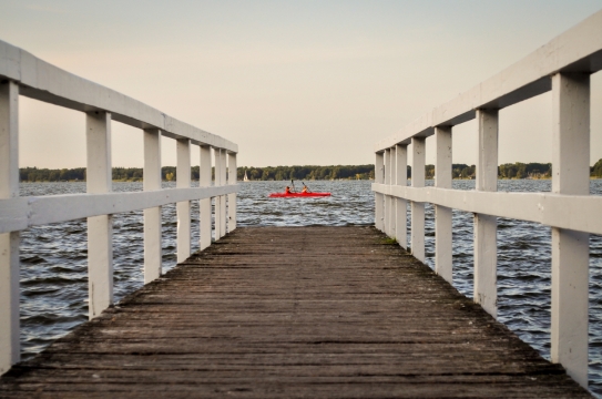 从木质栏杆小桥看湖畔湖面小船