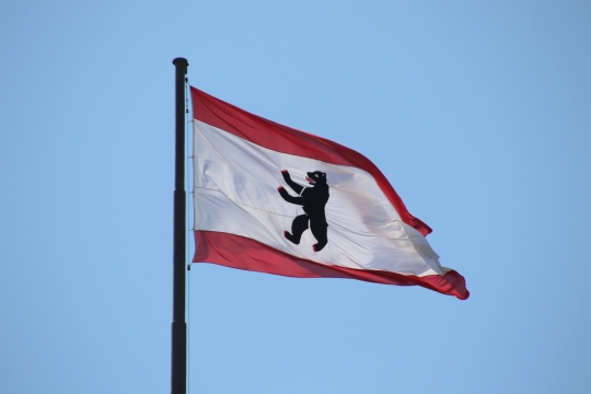 阳光蓝色天空飘扬德国柏林市旗