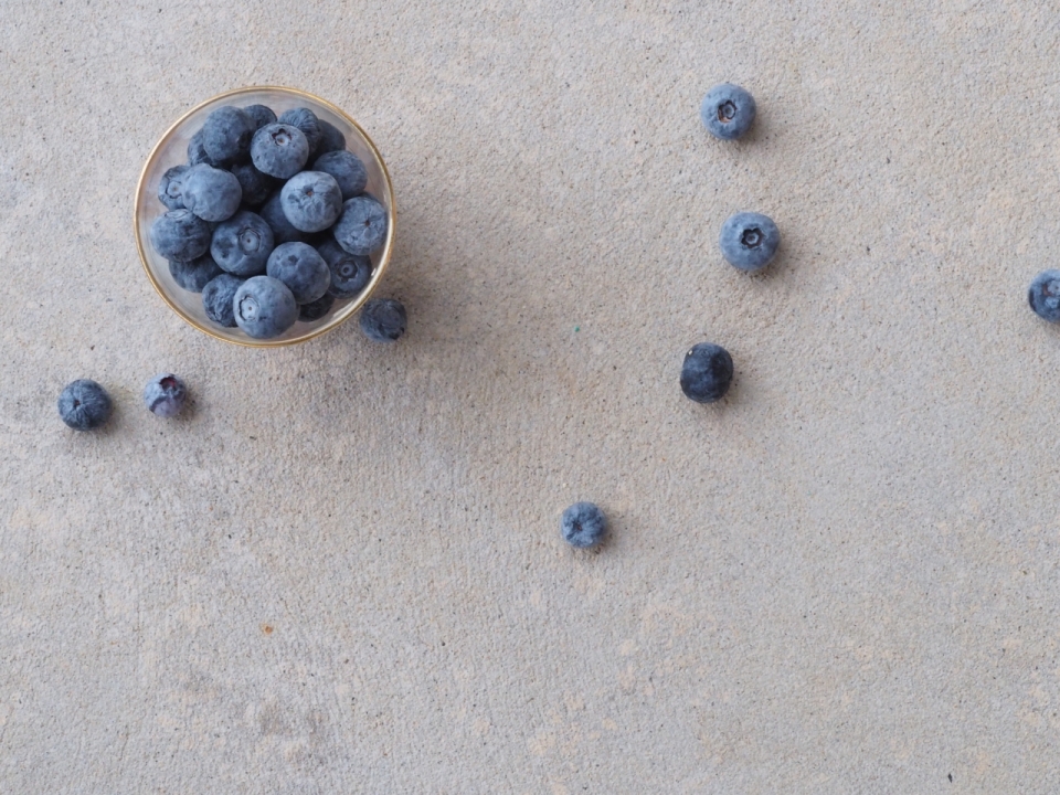 俯拍杯中及散落的蓝莓