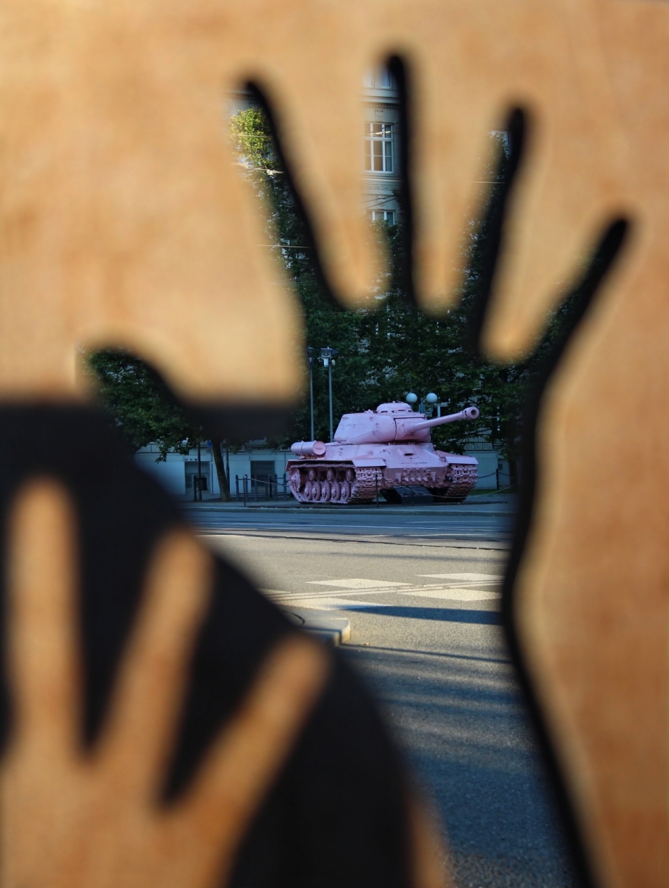 虚化手掌外粉红色的坦克停在马路上
