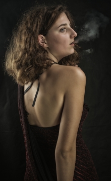 人物摄影_黑色背景吐烟金色卷发美女背面