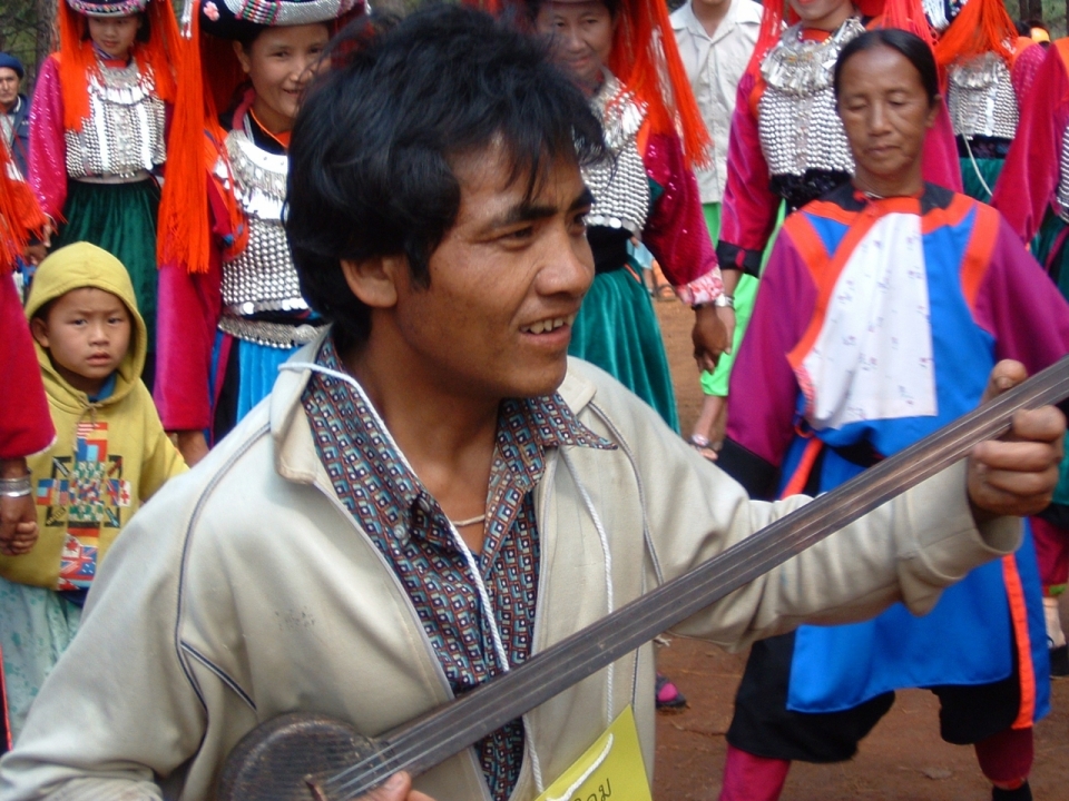 传统民族装扮女性前男性弹奏乐器