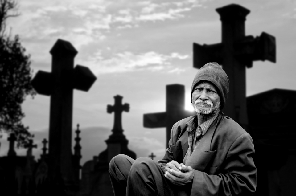 一位坐在墓地前的沧桑老人黑白摄影