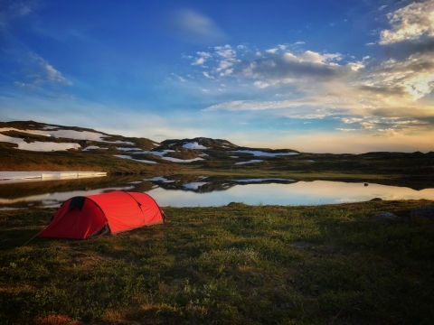蓝天雪山和湖泊旁边的红色帐篷风景摄影