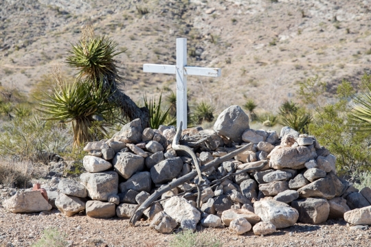 室外阳光下自然岩石石堆上白色十字架