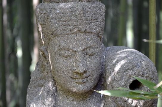 竹林间一个肩上扛着罐子的男人雕像