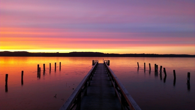 傍晚阳光天空湖泊前木制桥梁