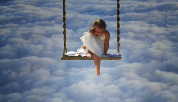 天空背景前秋千白色连衣裙女孩