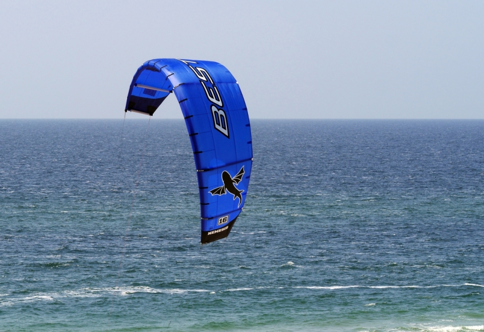 海面上漂行的蓝色滑翔伞特效摄影