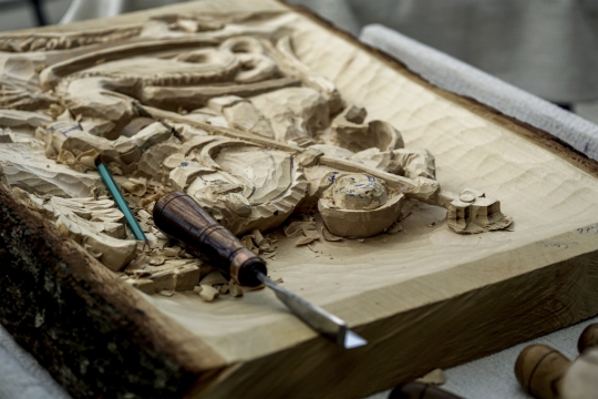 工作台上正在制作中的木雕与工具