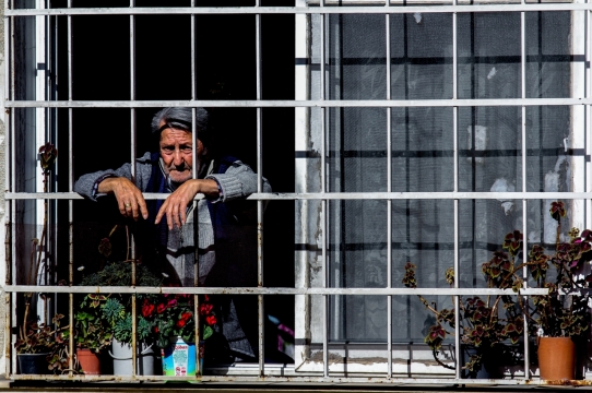 阳光城市街道趴窗户老年男性