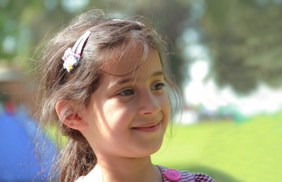 夏天阳光中微笑的棕色长发束马尾女孩