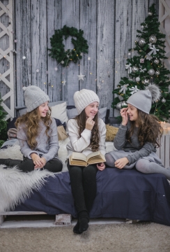 圣诞树前床上开心交谈的小女孩们