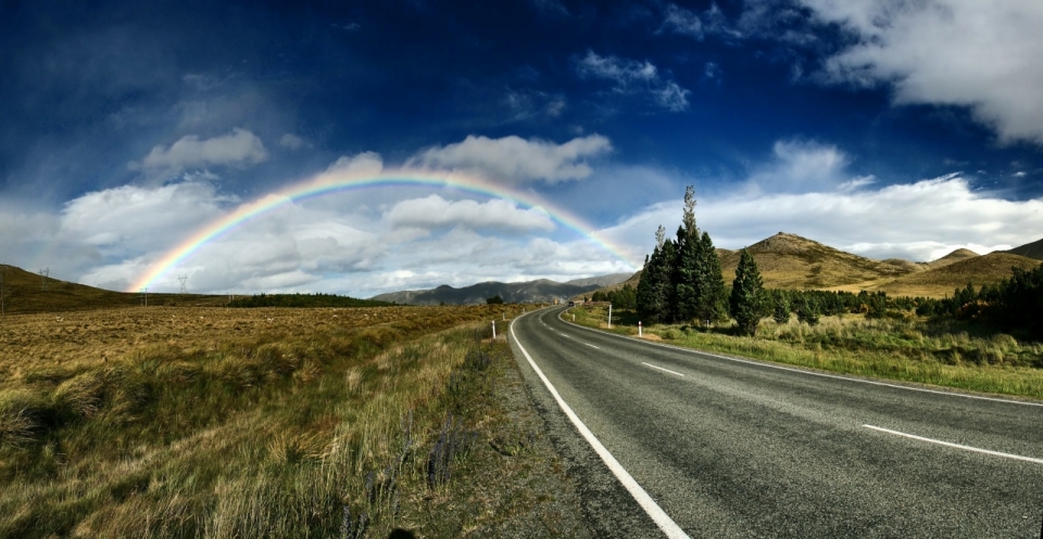 蓝天白云下道路上的七色彩虹
