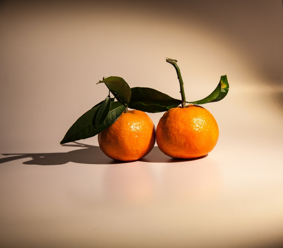 白色桌面灯光照射下的橘子水果摄影