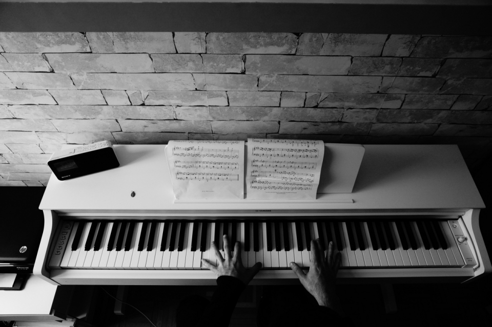 正在弹钢琴的人手部和钢琴黑白特写摄影