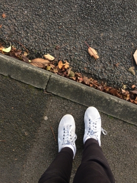 落叶马路边人行道上的脚部特写