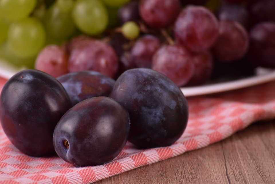 木桌上盘中摆放的美味葡萄水果
