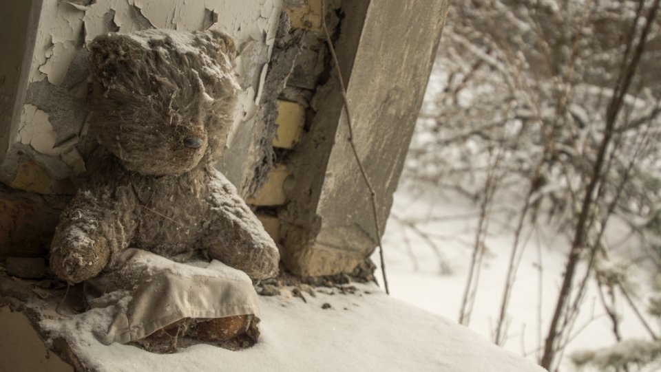 冬天雪后窗边破旧毛绒玩具熊