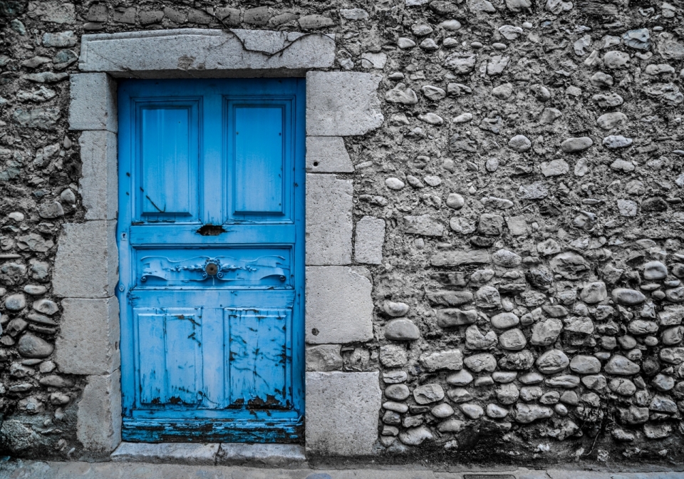 石头墙里的蓝色破旧木门建筑摄影