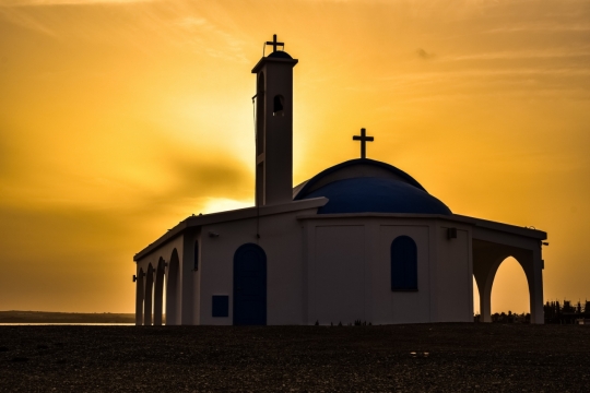 璀璨霞光映照教堂建筑十字架装饰外墙