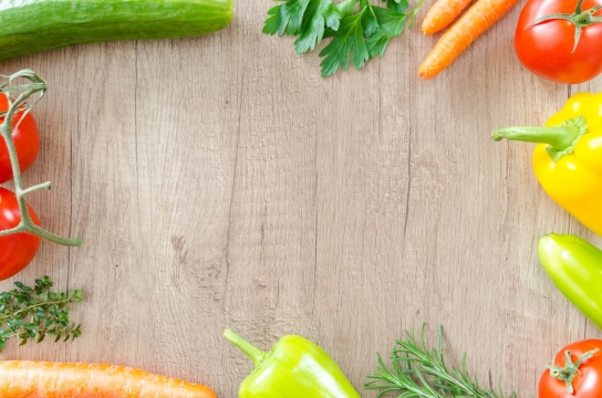 木桌上放着西红柿和胡萝卜等蔬菜