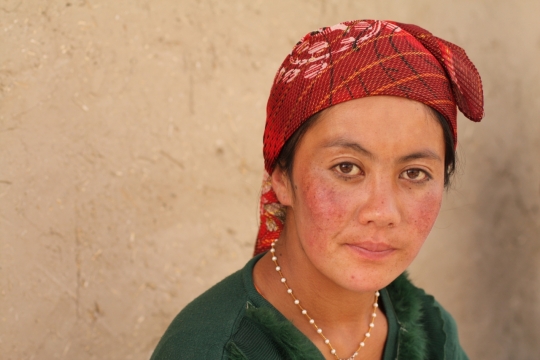 街道墙壁前红色头巾中年女性