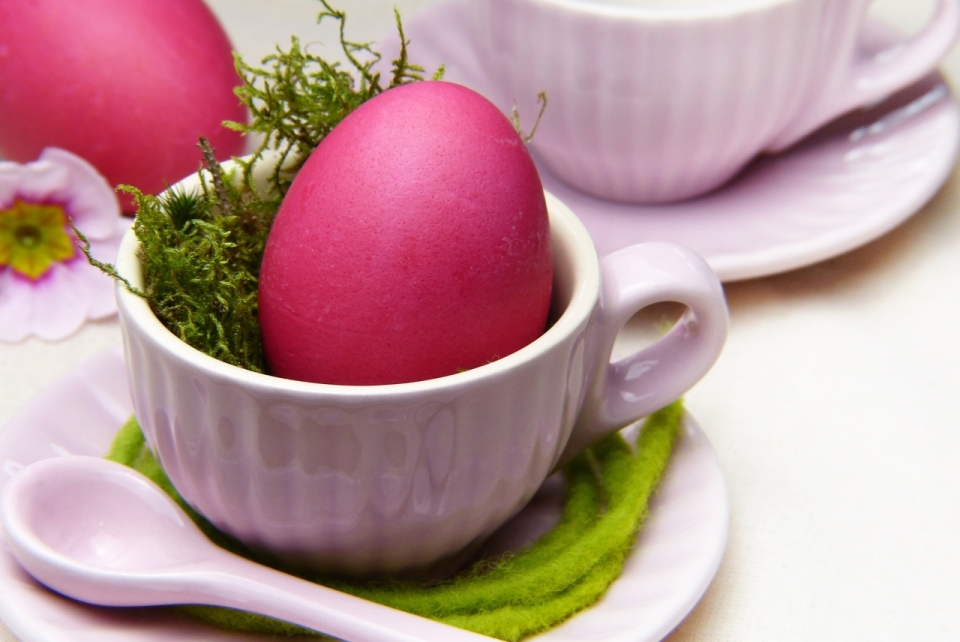 室内白色桌面杯子中复活节粉色彩蛋