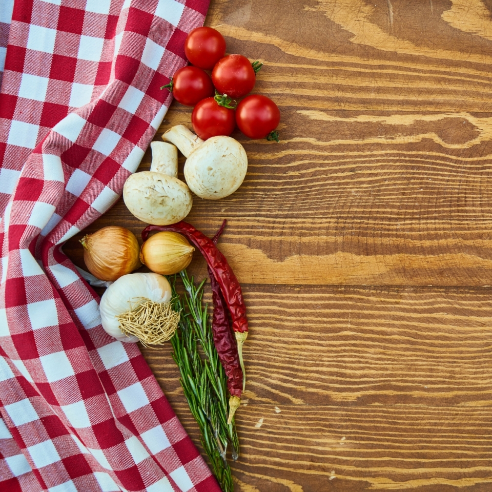 木质餐桌上桌布和蘑菇番茄辣椒食材摄影